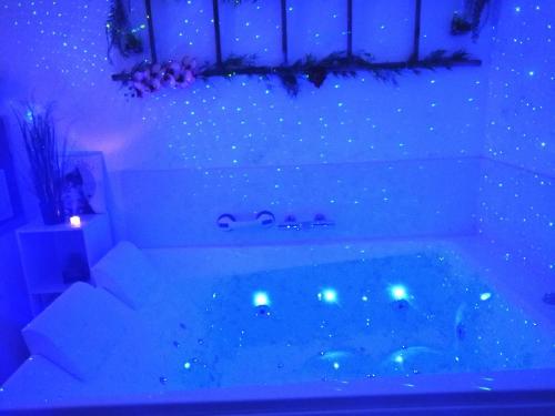 - une baignoire avec des lumières bleues dans la chambre dans l'établissement Le 1965 Double BALNEO, confort et romantique, à Grenoble