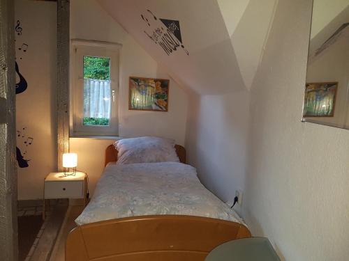 een kleine slaapkamer met een bed en een raam bij Ferienwohnung Kunterbunt in Winterberg