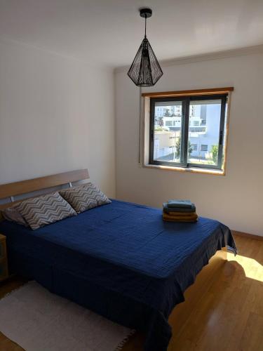 a bedroom with a blue bed with a window at Apartamento do Paço do Lumiar in Lisbon