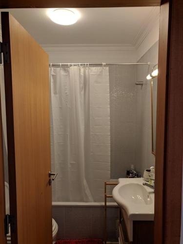 ein Bad mit einem Duschvorhang und einem Waschbecken in der Unterkunft Apartamento do Paço do Lumiar in Lissabon