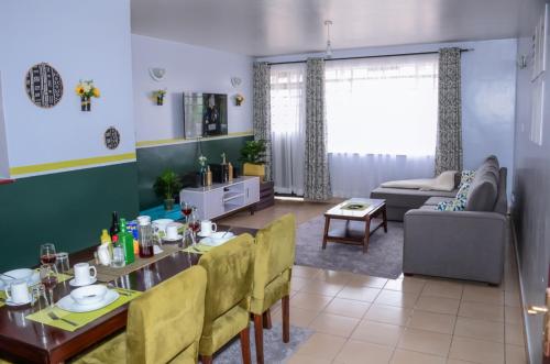 a dining room and living room with a table and chairs at Hirwado Homes in Nairobi