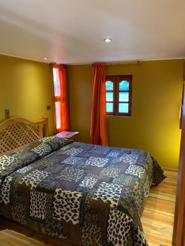 a bedroom with a bed with a blue and white comforter at Hostal Corvatsch in San Pedro de Atacama