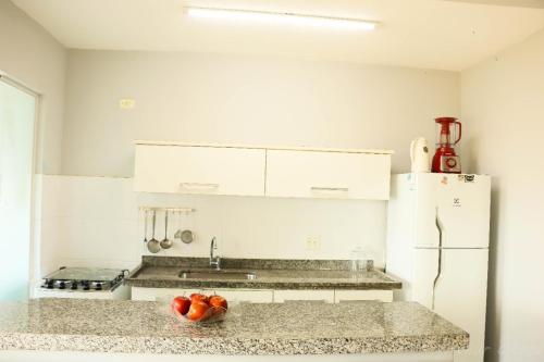 a kitchen with a bowl of fruit on a counter at Apto 2 dormitórios à 400 m da Praia de Riviera de São Lourenço - com serviço de praia in Bertioga