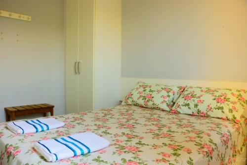 1 dormitorio con 1 cama con 2 almohadas en Apto 2 dormitórios à 400 m da Praia de Riviera de São Lourenço - com serviço de praia, en Bertioga