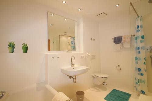 uma casa de banho com um lavatório, um WC e um espelho. em Hotel-Gasthof Rose em Oberammergau