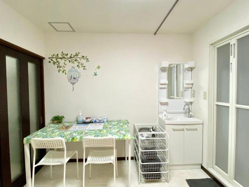 a kitchen with a table and chairs and a sink at 松戸の快適ロフトベッド1DK 長期滞在にも Nomad松戸宿005 in Matsudo