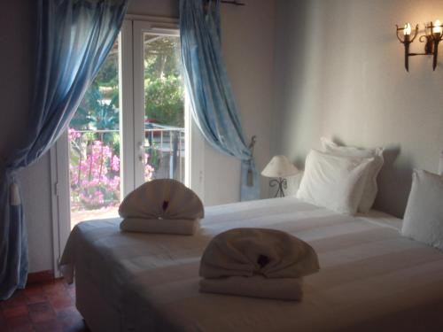 a bedroom with a bed with two pillows on it at Le Jardin d Eden in Sainte-Maxime