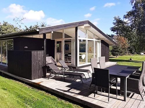 een kleine hut met een tafel en stoelen op een terras bij 5 person holiday home in Odder in Odder
