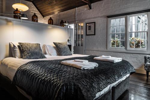 1 dormitorio con 1 cama grande y 2 toallas. en Old Bishop's Quarters Hobart, en Hobart