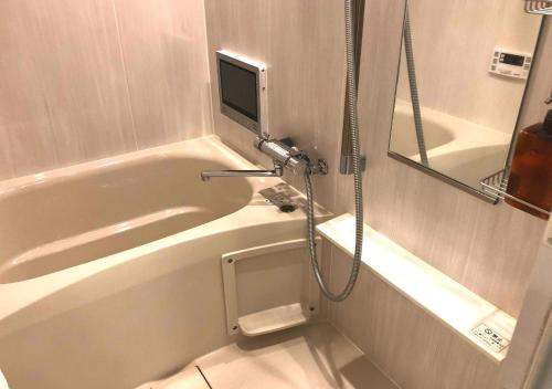 a bathroom with a tub and a tv on the wall at リブシティ錦糸町参番館上層階スカイツリーの眺望 in Tokyo