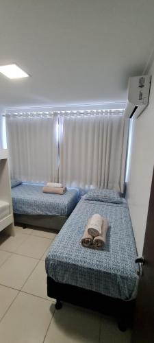 2 posti letto in camera con asciugamani di Apt. Cond. Barra Bali a Barra de São Miguel