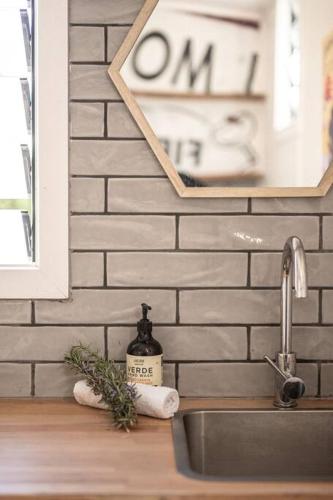 a kitchen counter with a sink and a clock on the wall at Mill Cottage in Tenterfield