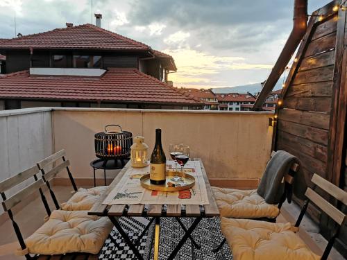 een tafel met twee glazen wijn op een balkon bij **Mountain** views just next to the gondola lift in Bansko