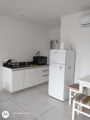 uma cozinha com um frigorífico branco e um micro-ondas em Departamento Serrano em Tandil