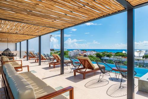 a patio with chairs and a view of the ocean at Kaab South Beach by The Spot Rentals in Playa del Carmen