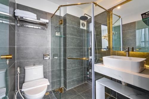 uma casa de banho com um chuveiro, um WC e um lavatório. em KunKin Luxury Hotel & Apartment em Ho Chi Minh