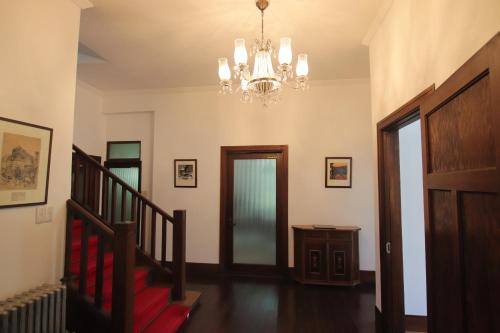 a room with a staircase and a chandelier at Yamaguchi House,Historic Private House with Open-Air Hot springs in Hakone