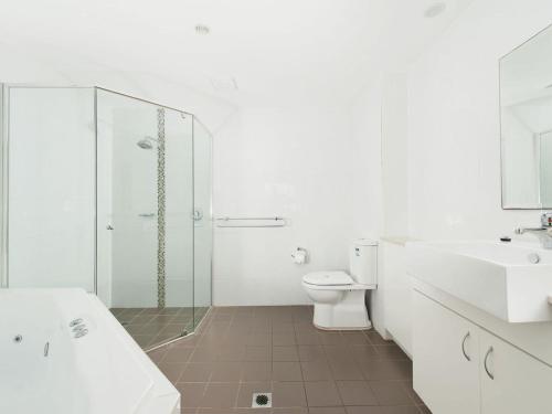 a bathroom with a shower and a toilet and a sink at Barefoot Bliss 4 in Fingal Bay