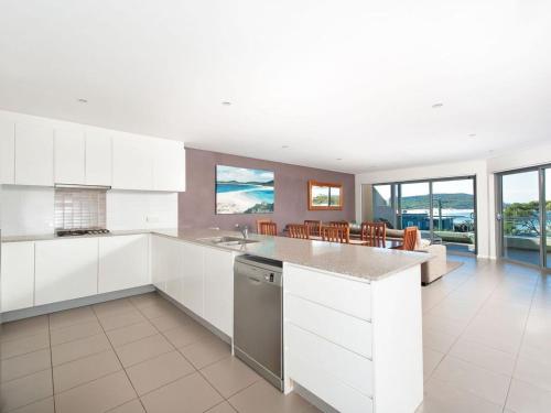 a kitchen with white cabinets and a counter top at Barefoot Bliss 4, 6-10 Market Street - Surfside Apartments in Fingal Bay