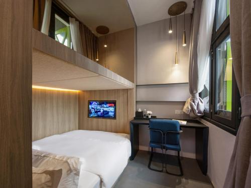 1 dormitorio con 1 cama, escritorio y TV en ST Signature Tanjong Pagar, en Singapur