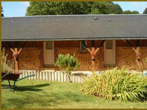 a brick house with a black roof in a yard at Auberge Les Tonnelles in Saint-Léonard