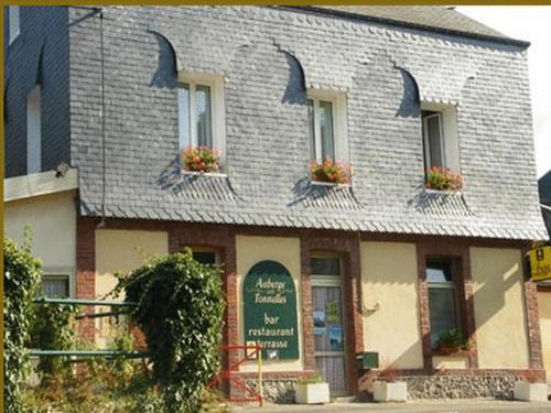 a building with a sign in front of it at Auberge Les Tonnelles in Saint-Léonard