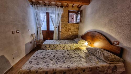 1 dormitorio con 2 camas y ventana en La casa della maestra località San Giovanni Spello, en Spello