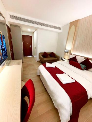 a hotel room with a large bed and a red chair at Falaj Daris Hotel in Nizwa