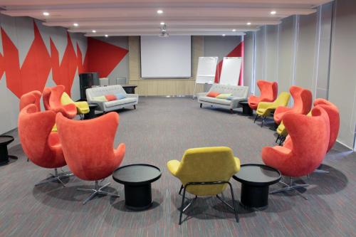 a conference room with chairs and a screen in the background at Ramada Meridin Johor Bahru in Nusajaya