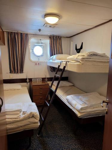 a room with two bunk beds and a window at Laivahostel S/S Bore in Turku