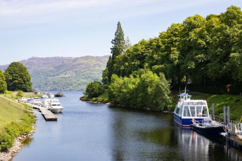 a group of boats are docked on a river at The Caledonian Hotel in Fort William