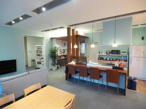 a kitchen and living room with a couch and a table at Choine Hotel Sapporo Teine in Sapporo