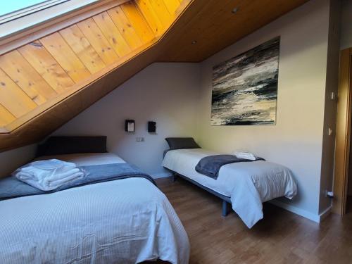 two beds in a room with an attic at New Dúplex a 25m del telecabina de La Massana 643 in La Massana