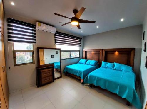 een slaapkamer met 2 bedden en een plafondventilator bij Suite FG in San Juan de los Lagos