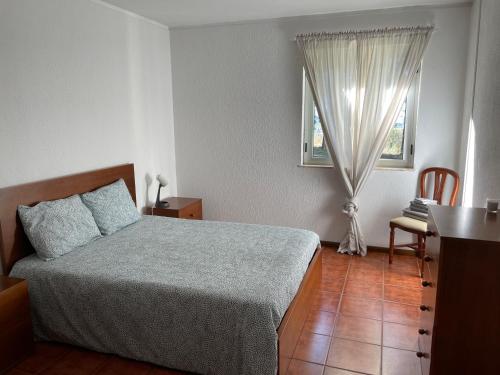 een slaapkamer met een bed, een tafel en een raam bij Bel Douro in Torre de Moncorvo