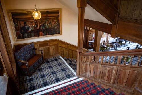 a living room with a staircase leading up to a staircase at The Highland Hotel in Strathpeffer