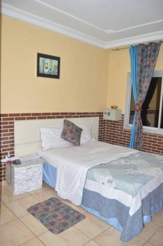 a bedroom with a bed and a window at Résidence Hotelière Borel Denver in Douala