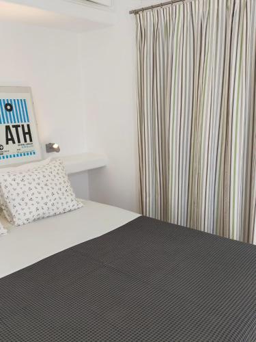 a bedroom with a bed and a window with a curtain at Chora Elegant Traditional House in Amorgos