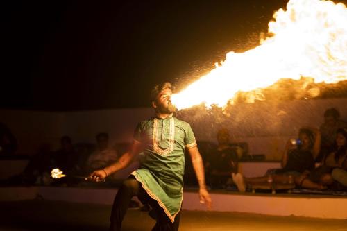 un hombre parado frente a un espectáculo de fuego en Sultan Resort, en Sām