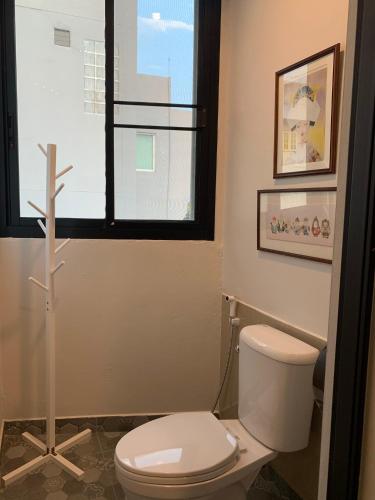 a bathroom with a toilet and a cross on the floor at Baannaisoi2home in Chiang Mai