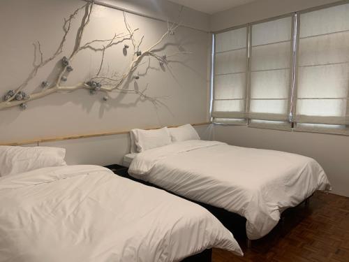 two beds sitting next to each other in a bedroom at Baannaisoi2home in Chiang Mai