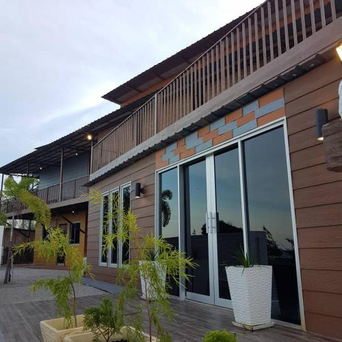 a building with large glass doors and potted plants at The Retreat Tanjung Jara in Kampong Gok Kapor