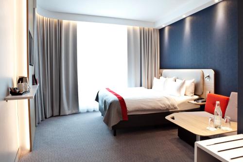 a hotel room with a bed and a table at Holiday Inn Express - Recklinghausen in Recklinghausen