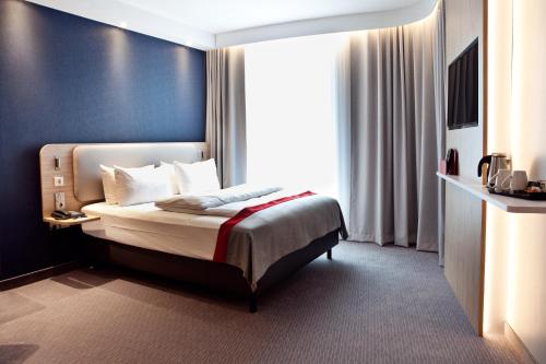 a hotel room with a bed and a window at Holiday Inn Express - Recklinghausen in Recklinghausen