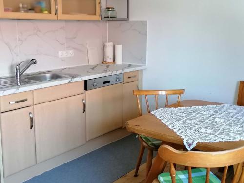 eine Küche mit einem Tisch und einem Waschbecken sowie einem Tisch und Stühlen in der Unterkunft Ferienhaus Josefine in Bad Endorf
