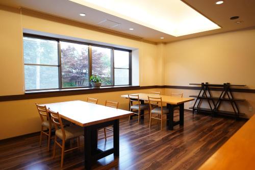a waiting room with tables and chairs and windows at Soumeian in Kusatsu