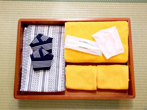 a wooden box with towels and ties in it at Lodge Koropokkuru in Kutchan