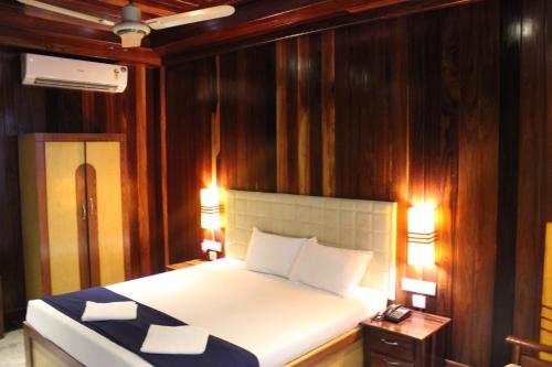 1 dormitorio con 1 cama con paneles de madera en las paredes en Hotel NK International en Aberdeen