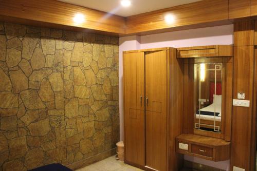 baño con pared de piedra y armario en Hotel NK International en Aberdeen