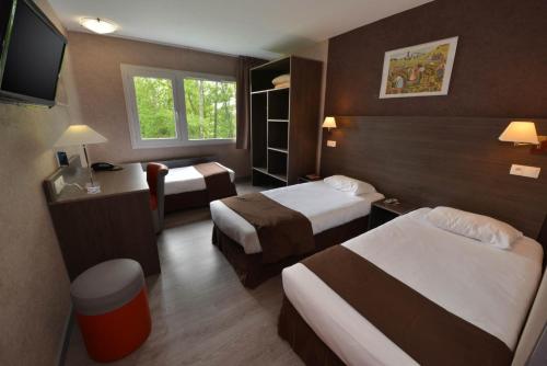 プイイ・アン・オオワにあるHotel du Val Vertのベッド2台とテレビが備わるホテルルームです。